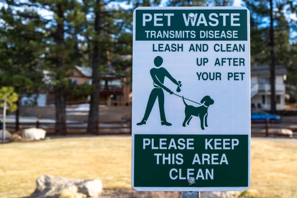 street sign inviting dog owners to clean up their waste to avoid the spread of diseases