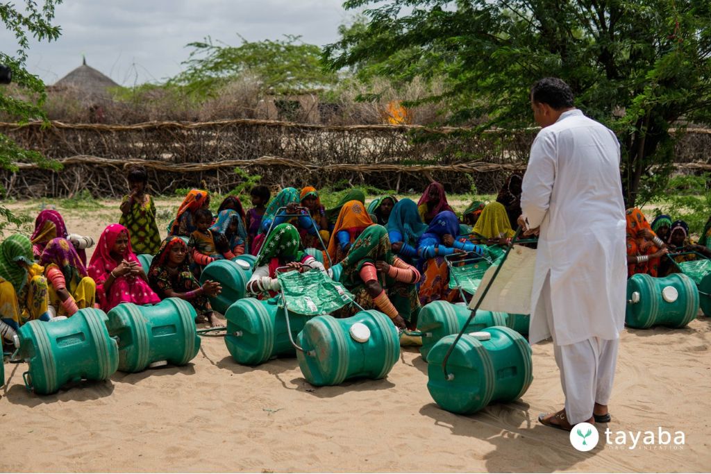 Umerkot: A representative from Tayaba demonstrates the use of the H2O Wheel to local women.