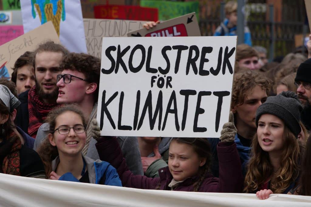 Greta Thunberg at a climate protest holding the sign “Skolstrejk för klimatet” – School strike for the Climate