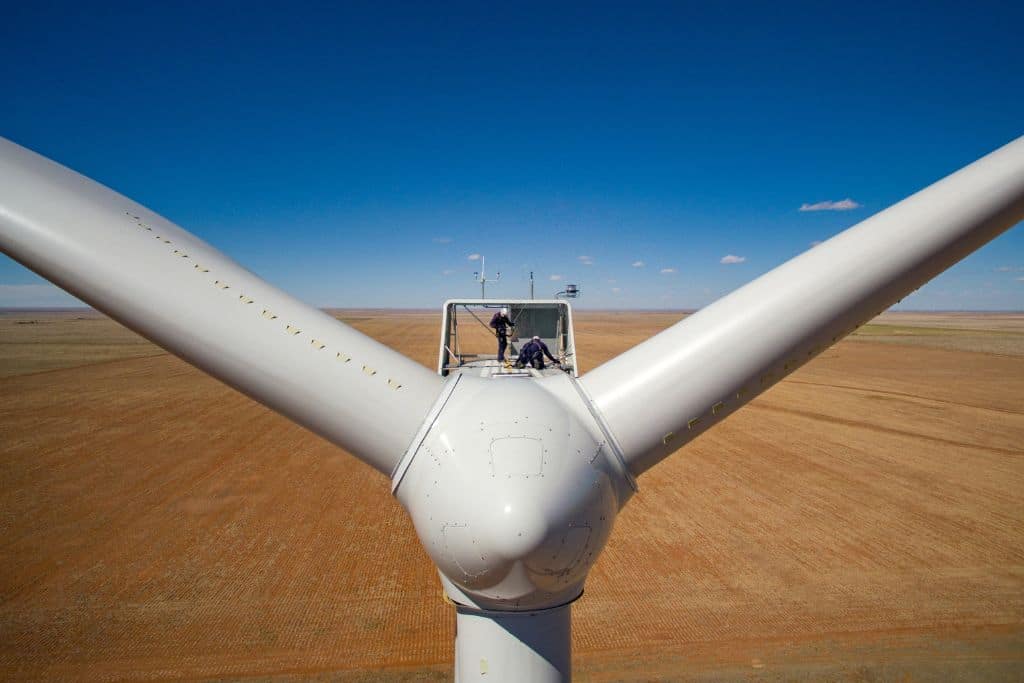 Two O&M wind technicians secure themselves with security harnesses to the top of a wind turbine during annual inspection of the Roosevelt wind farm in eastern New Mexico. Photo taken in May 2016